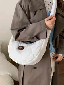 White quilted crescent dumpling bag with heart embroidery and wide shoulder strap