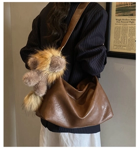 Sac hobo vintage en cuir marron avec large bandoulière et pendentif en peluche doux