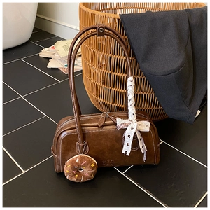 Détail d'un sac rétro en similicuir marron avec ruban de dentelle et porte-clés donut