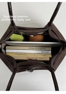 Spacious interior of dark brown suede tote bag showing laptop and book storage