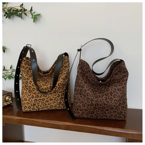 Detail of leopard print tote bags with black leather straps and silver metal studs