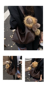 Détail d'un sac cabas vintage marron foncé avec un porte-clés peluche en extérieur