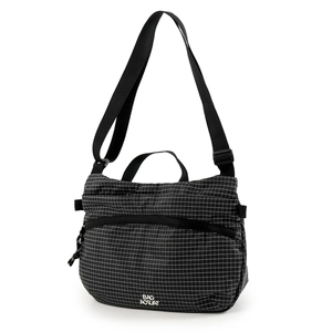 Détail d'un sac bandoulière étanche avec motif quadrillé blanc et fermeture éclair avant