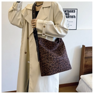 Macro detail of leopard print tote bag with black adjustable leather eyelet strap