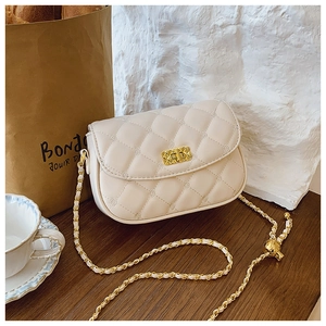 Detail of a beige quilted crossbody bag with gold twist lock and metallic chain strap