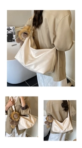 Détail d'un sac cabas en cuir souple blanc crème avec poignée dorée et breloque en peluche
