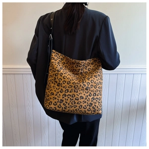 Close-up of leopard print tote bag featuring black shoulder strap and soft velvet texture