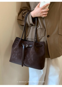 Detail shot of vintage dark brown suede tote bag with belt buckle and logo lettering