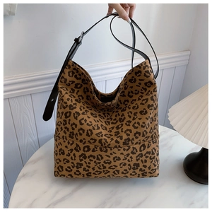 Macro view of leopard print tote bag fabric and adjustable black synthetic leather strap