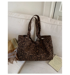 Close-up of a large leopard print canvas tote bag on a cozy white sofa for casual styling