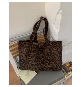Detail view of large leopard print tote bag on a grey chair in a modern room setting