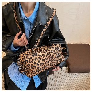 Détail du sac boston léopard avec bandoulière à œillets métalliques sur veste