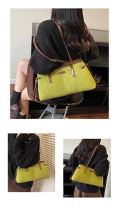 Detail of avocado green suede tote bag with brown leather trim and metallic brand logo