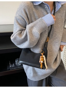 Sac à bandoulière chic en toile et cuir noir avec accessoire de charme perlé rétro