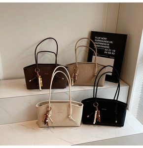 Retro tote bags in four colors with wooden bead charms and minimalist golden logo