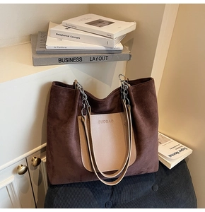 Detail of suede-like tote bag showing brown texture and chain leather shoulder strap