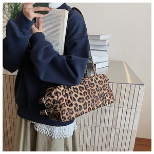 Détail du sac Boston imprimé léopard avec boucle métallique et texture vintage