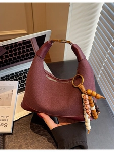 Sac hobo bordeaux en forme de croissant avec pendentif en perles et design minimaliste