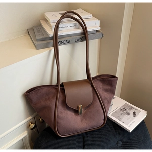 Close-up of vintage brown suede tote bag with golden metal buckle and leather strap