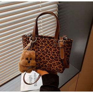 Dettaglio della borsa tote leopardata in pelle scamosciata con manici in pelle marrone
