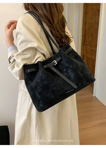 Model view of black suede tote bag with slim shoulder straps and minimalist retro design
