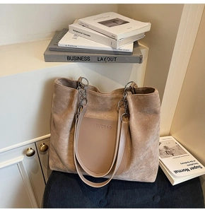 Detail of khaki suede tote bag with chain strap and smooth leather front pocket