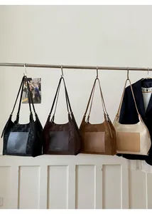 Detail view of large faux suede tote bags in four colors with front pocket and gold logo