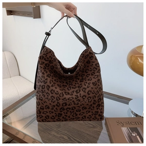 Detail shot of leopard print hobo bag with adjustable strap on a glass table