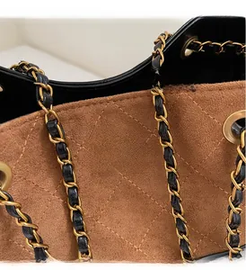 Detail der braunen Wildledertasche mit Rautensteppung und goldenem Drehverschluss