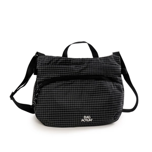 Détail du sac bandoulière à carreaux noir et blanc avec sangle réglable et poche zippée