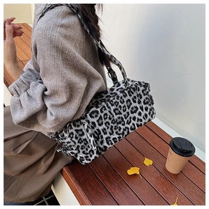Vue de dessus d'un sac Boston à imprimé léopard noir et blanc sur un banc en bois