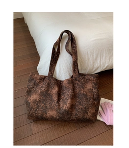 Close-up of leopard print canvas tote bag on white bedding in a cozy room setting