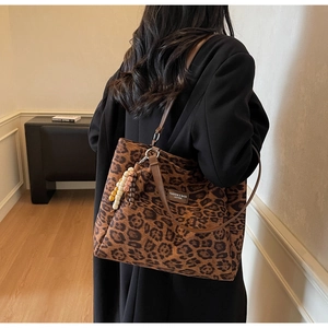 Detail of leopard print tote bag with brown leather handles and decorative colorful beads