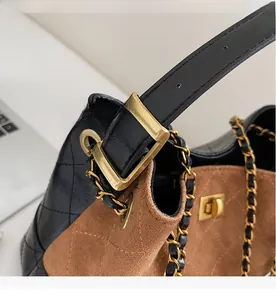 Details des goldfarbenen Kettenriemens und der Metallschnalle an der Stepptasche