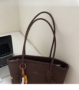 Close-up of retro brown tote bag with beaded tassel and comfortable shoulder straps
