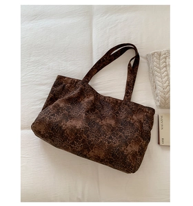 Macro detail of large leopard print tote bag texture and durable canvas shoulder strap