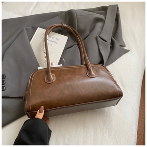 Détail du sac baguette vintage marron avec surpiqûres blanches contrastées sur le cuir