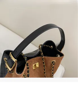 Detail von Kontrastnähten, Golddrehverschluss und Kettenriemen an einer Shopper-Tasche
