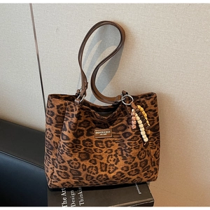 Detailed leopard print tote bag featuring a leather logo tag and colorful beaded charm