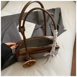 Vue détaillée de l'intérieur du sac en cuir marron foncé avec accessoire en dentelle
