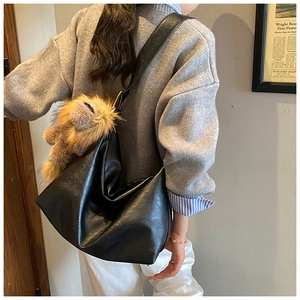 Détail du sac à bandoulière noir en similicuir avec un charmant lion en peluche