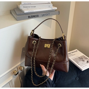Detailansicht der braunen gesteppten Ledertasche mit goldener Kette und Drehverschluss