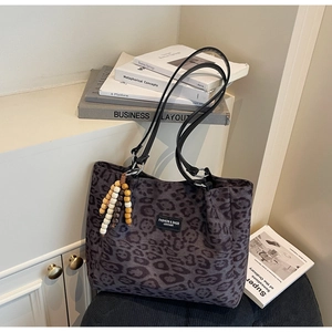Detailed view of dark purple leopard print tote bag with plush velvet texture and wooden beads