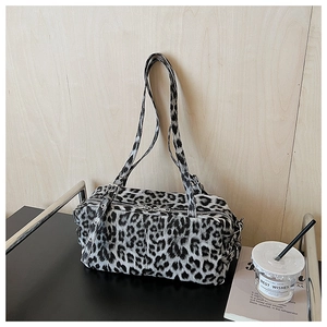Détail de la texture léopard en fausse fourrure et boucles en métal argenté du sac polochon