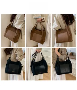 Detail of large suede tote bag with contrast leather pocket and adjustable strap