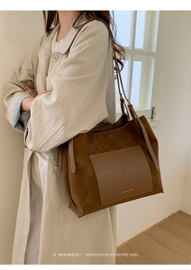 Close-up of brown suede and smooth leather patchwork tote with fine stitching
