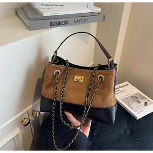 Detailansicht der braunen Wildleder- und schwarzen Steppledertasche mit Goldkette