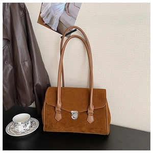 Detail of vintage brown suede shoulder bag with silver metal swivel lock and slim straps