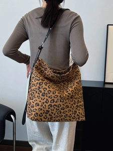 Chic leopard print large hobo bag with adjustable black strap on a shoulder model