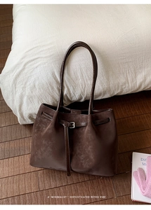 Detail shot of the vintage dark brown suede tote bag featuring a decorative metal buckle strap